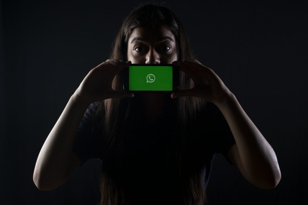 woman-holding-black-smartphone-at-whatsapp-logo